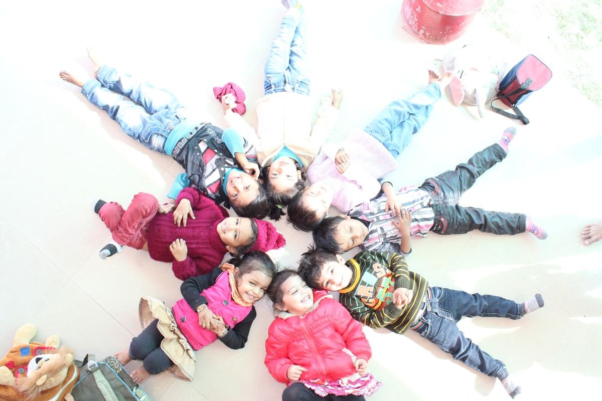 Children lying in a circle, seen from above